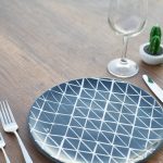 round blue and white ceramic plate two forks two knives and wine glass